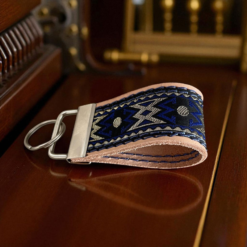 Mit Brokatband vernäht - edler Schlüsselanhänger aus pflanzlich gegerbtem Leder mit Ziernähten und silberfarbener Schließe